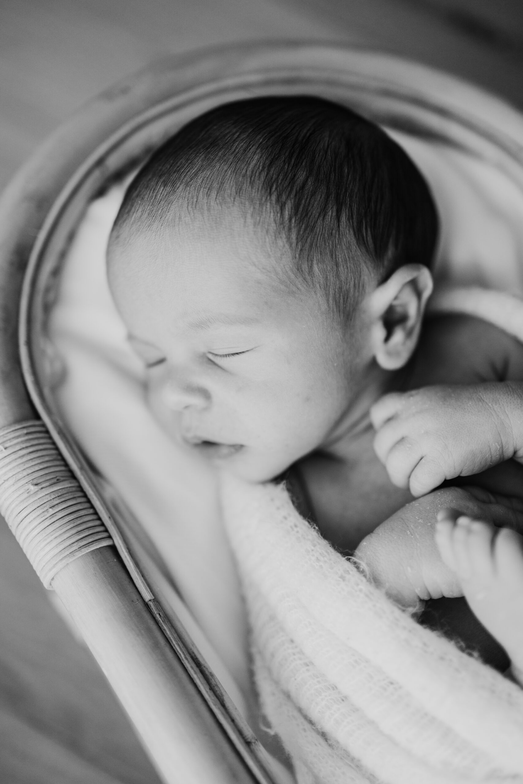 Schlafendes Baby in einem Bambusbett aufgenommen bei einem Neugeborenen Fotoshooting im Zürich Oberland