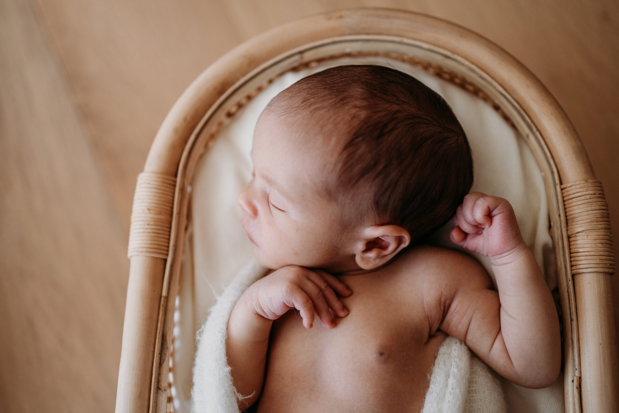 Schlafendes Baby in einem Bambusbett aufgenommen bei einem Neugeborenen Fotoshooting im Zürich Oberland