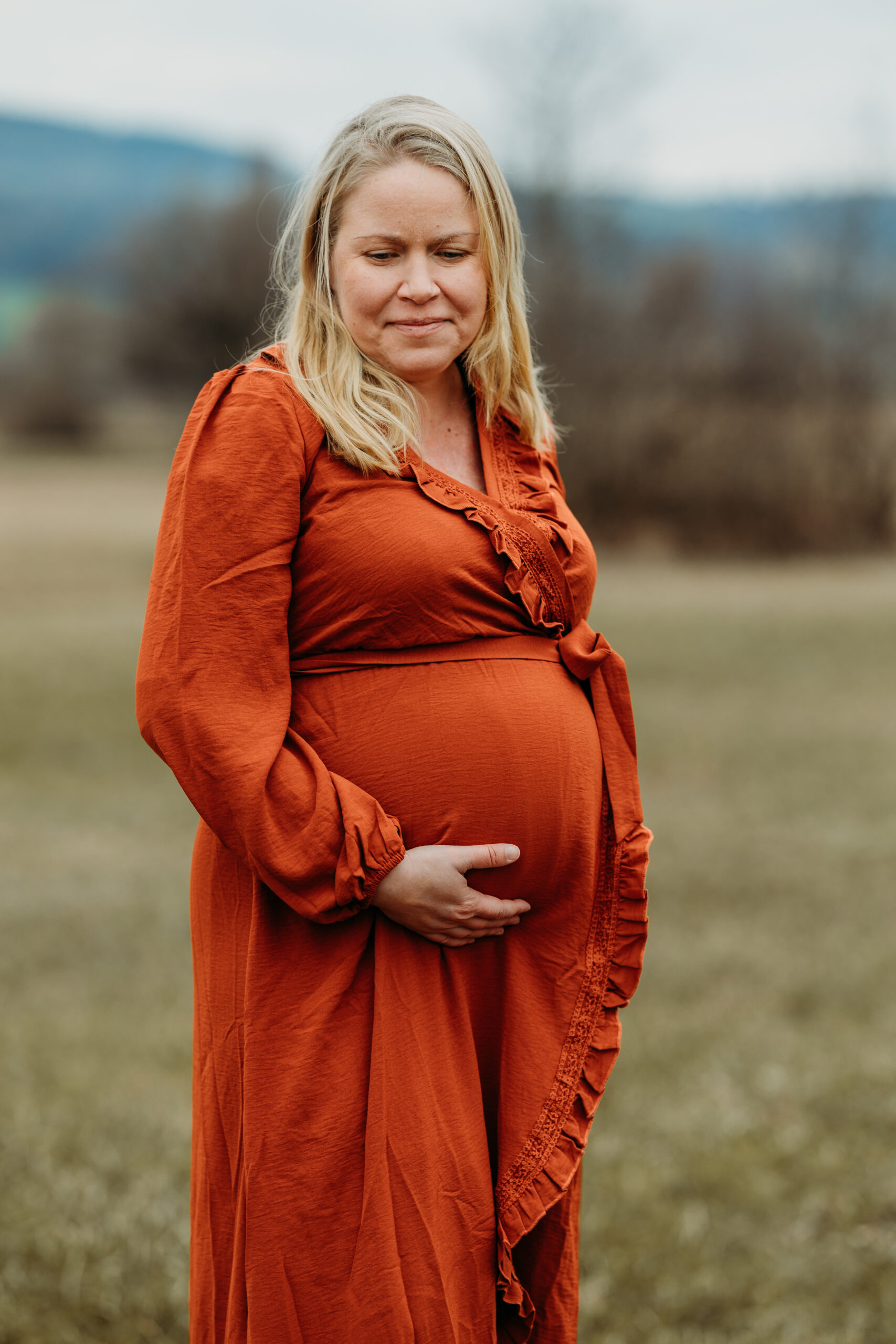 Schwangere in der Natur am Greifensee in einem schönem orangen Kleid