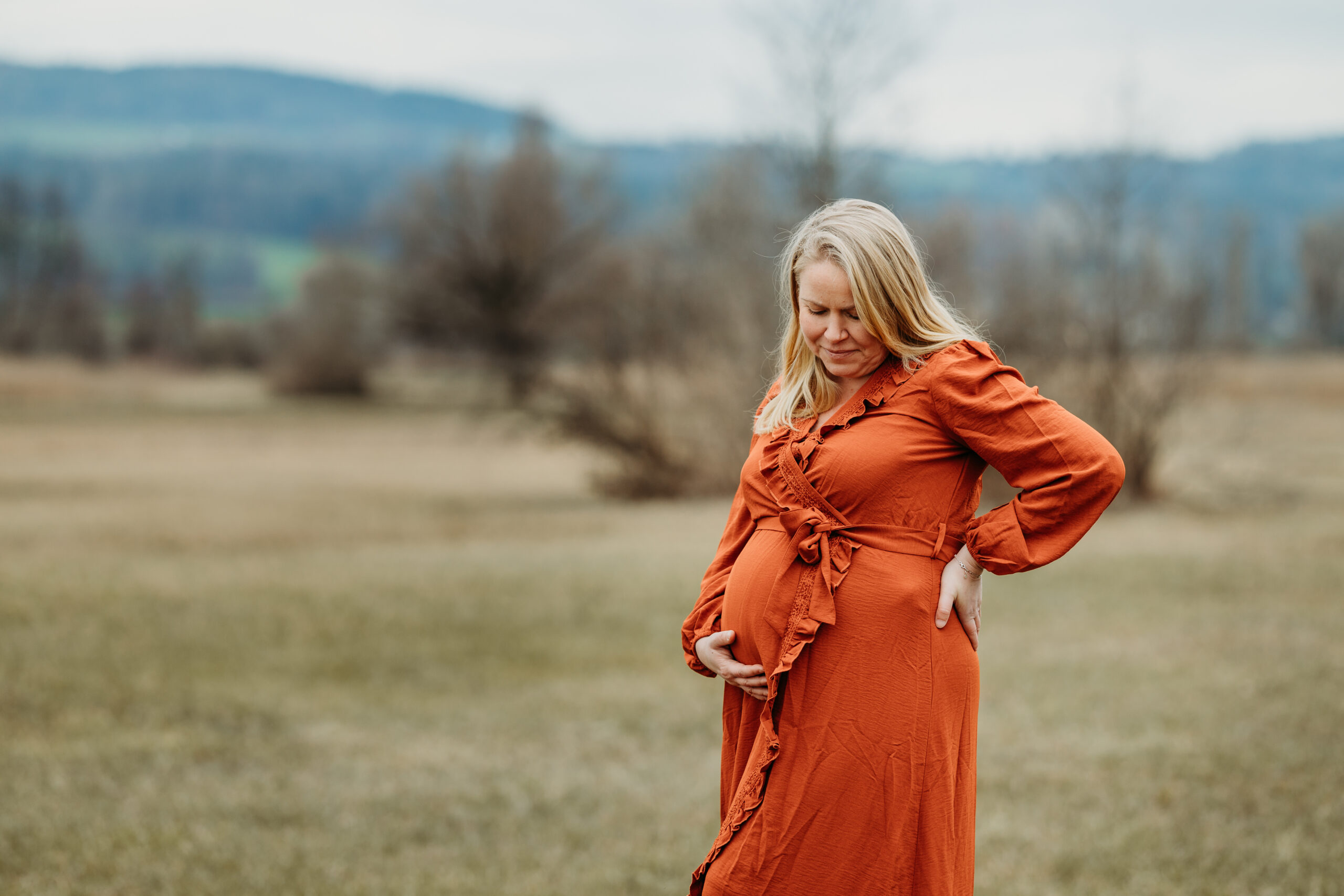 Schwangere in der Natur am Greifensee in einem schönem orangen Kleid