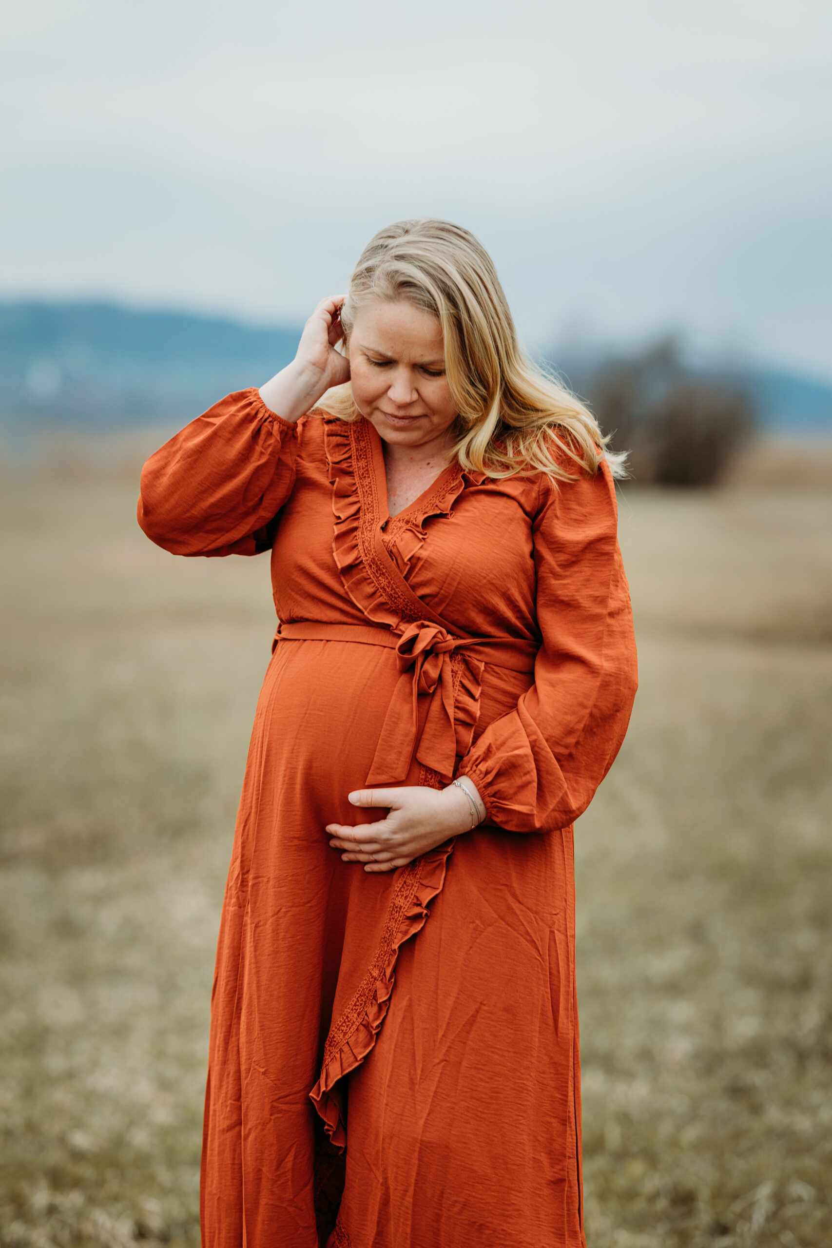 Schwangere in der Natur am Greifensee in einem schönem orangen Kleid